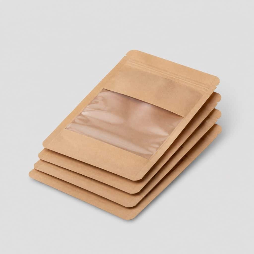 Quatre pochettes kraft avec fenêtre PVC transparente posées en pile
