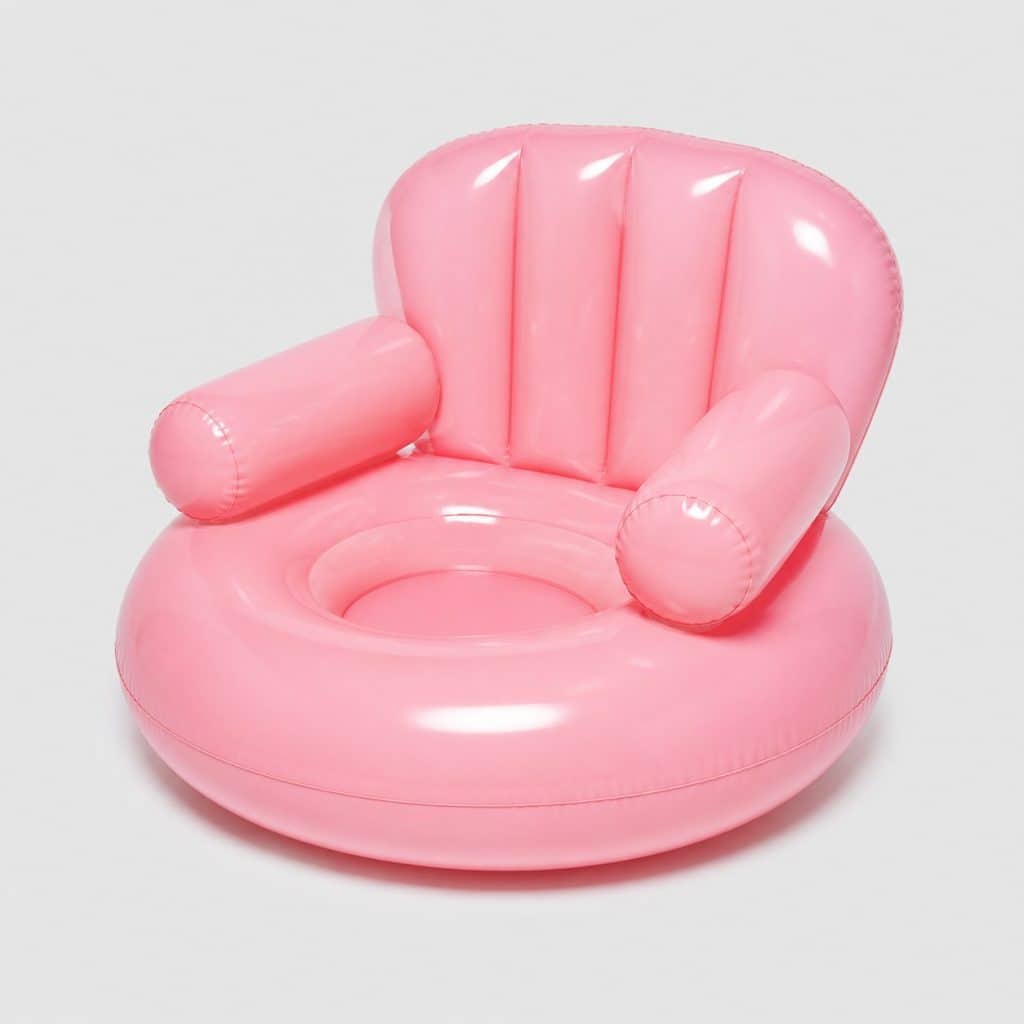 Chaise flottante gonflable rose avec dossier sur fond clair