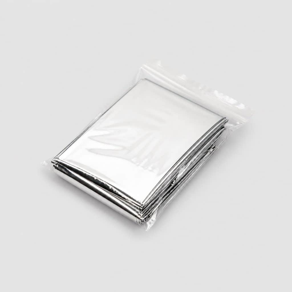 Couverture de survie argentée très brillante pliée dans sa pochette