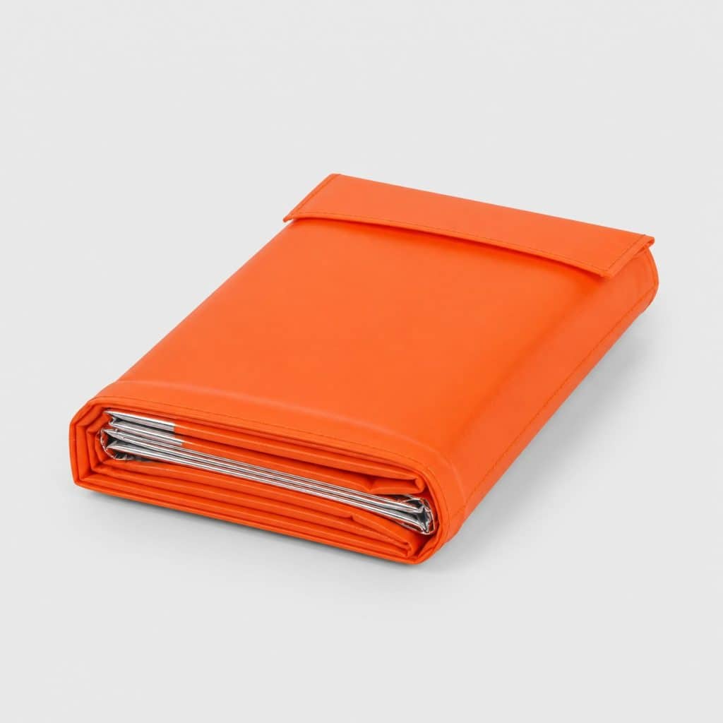 Couverture de survie orange vif pliée dans sa pochette