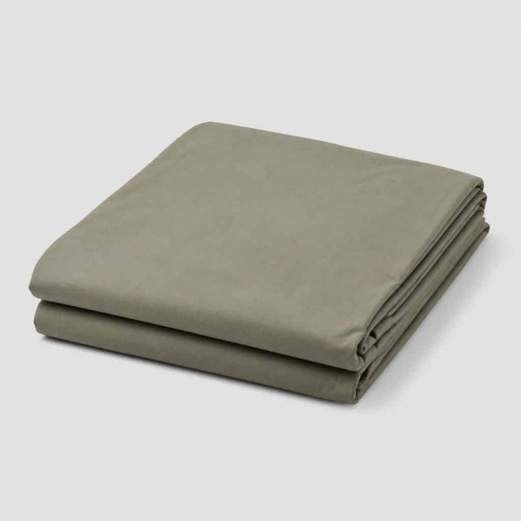Drap de sac de couchage en coton plié sur fond clair