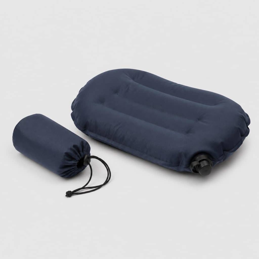 Oreiller gonflable de camping dégonflé avec sa pochette sur fond clair