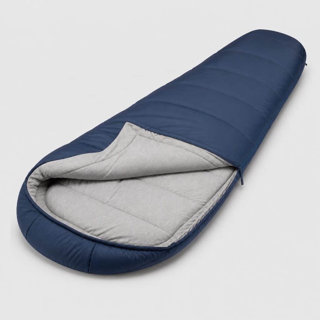 Sac de couchage de camping avec doublure en coton ouvert sur fond clair