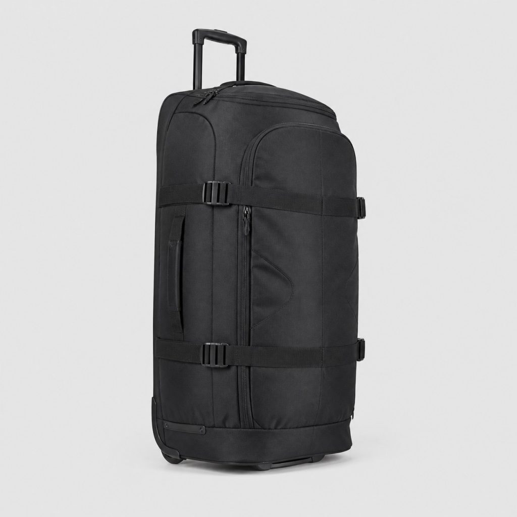 Sac de voyage souple à roulettes debout sur fond clair
